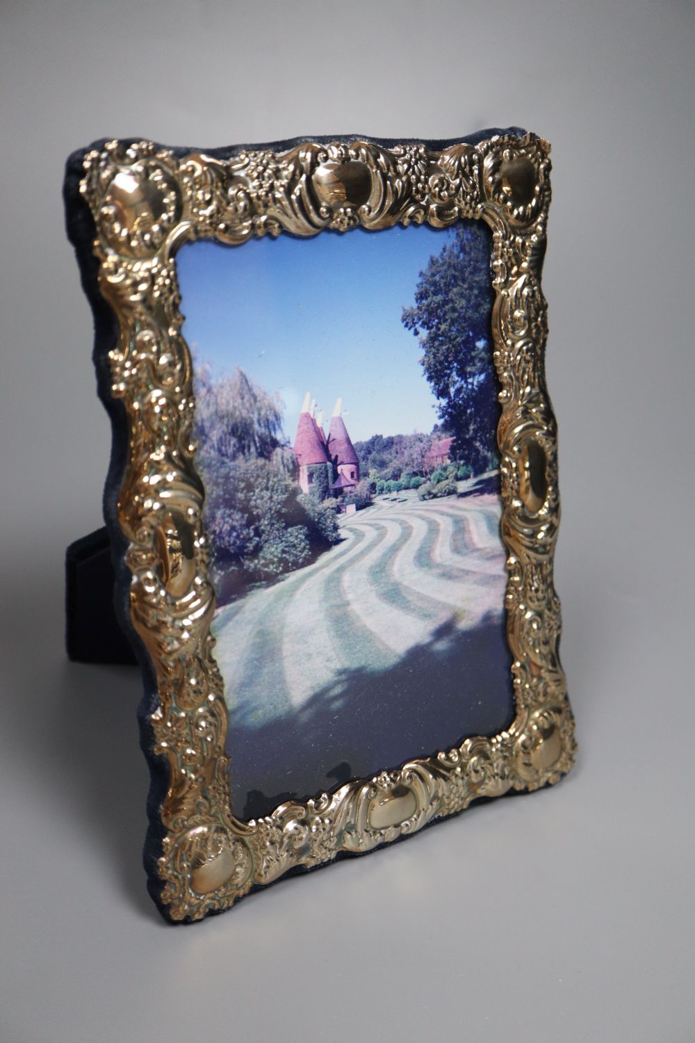 A small Persian white metal dish with inset coin, 67mm, a sterling small vase and a modern silver photograph frame.